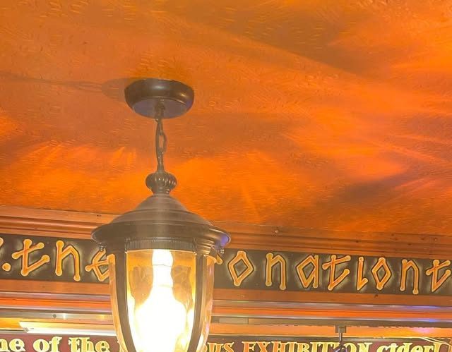 A lantern under the gold-lettered gantry spelling 'The Coronation Tap'